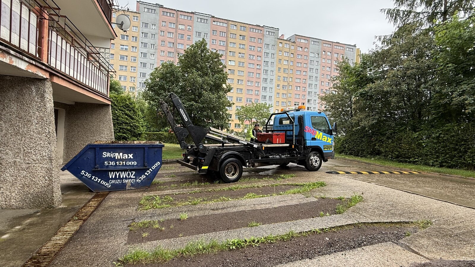 Bramowiec i kontener SKIPMAX przy bloku